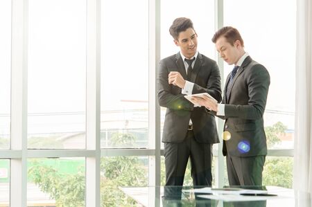 business partners discussing documents and ideas in officeの写真素材