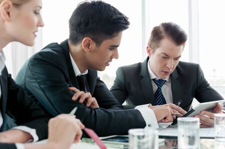 business partners discussing documents and ideas at meetingの写真素材