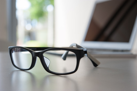 close up glasses on work desk with laptopの写真素材
