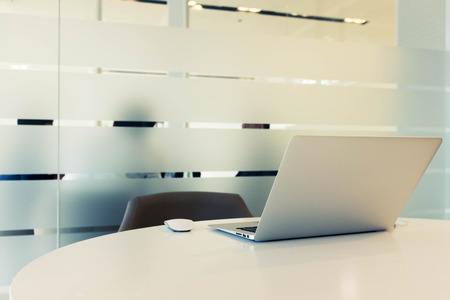 Laptop on table and people in other roomの写真素材