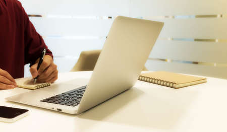 cropped shot of a young man working from home using laptop computer, man at his workplace using technologyの写真素材