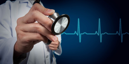 Doctor use stethoscope with heart beat graph in backgroundの写真素材