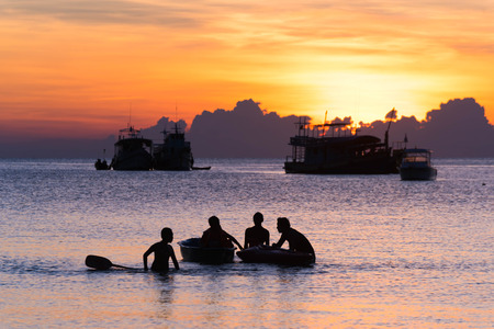 Silhouette of a group of teenager play together in the canoeの写真素材