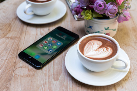 CHIANG MAI, THAILAND - NOVEMBER 14th, 2016: Latte art with Iphone7 plus with social media icon onscreen, smartphone life style, smartphone in everyday life, age of smartphoneのeditorial素材
