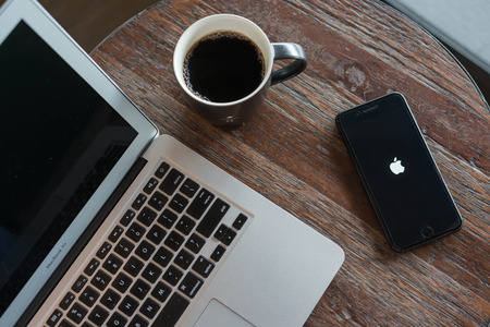 BANGKOK, THAILAND - NOVEMBER 26, 2016: Iphone7 Plus jet black serie on opening screen of Apple inc. icon with macbook airのeditorial素材