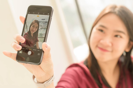 Bangkok ,Thailand DECEMBER 04, 2016 : Pretty young woman take selfie short by Iphone 7 Plus jet black seriesのeditorial素材