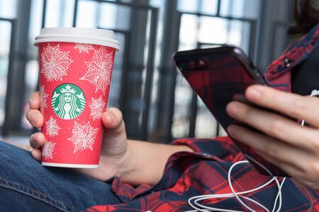 Bangkok ,Thailand November 27 : woman hold starbucks hot beverage cup in Christmas theme using...