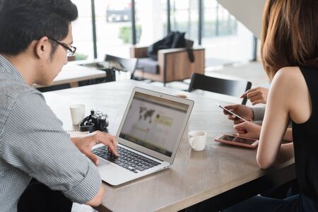 Group of friends meeting in a coffee shop chatting to each other while using smartphone tablet and laptop, internet of things conceptualの写真素材
