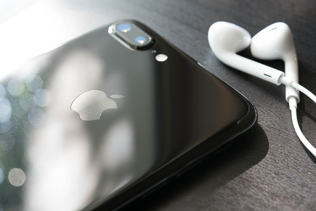 BANGKOK, THAILAND - NOVEMBER 26, 2016: Iphone7 Plus jet black serie face down on floor with ear phone, Apple inc new smartphoneのeditorial素材