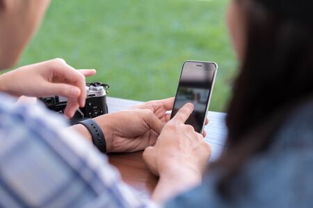 Three people using smartphone together, sharing photo, internet of things conceptual