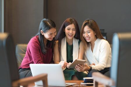 Group of friends meeting in a coffee shop chatting to each other while using smartphone tablet and laptop, internet of things conceptualの写真素材