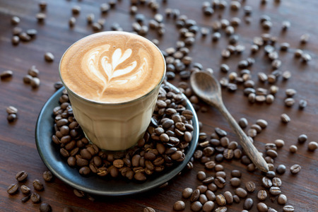 Top view of fresh coffe, latte art with coffee bean on wooden tableの写真素材