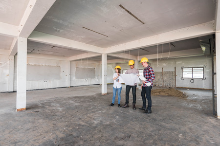 three construction engineers working together in side buiding planning for the renovationの写真素材