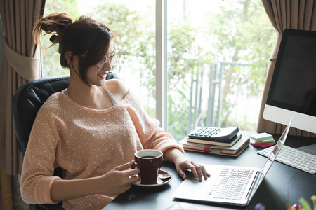 Young entrepreneur, teenager business owner work at home, alpha generation life style. morning coffee of an asian teenagerの写真素材