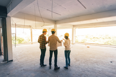 three construction engineers working together in side buiding planning for the renovationの写真素材