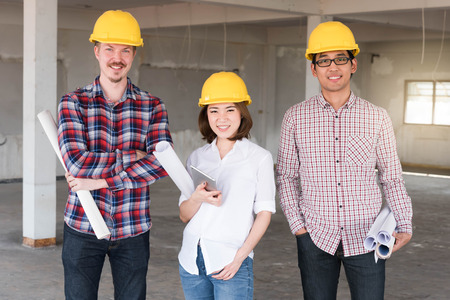 three construction engineers working together in construction site planning for the renovationの写真素材
