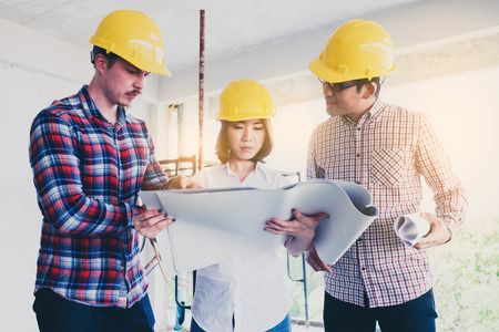 three construction engineers working together in side building planning for the renovationの写真素材