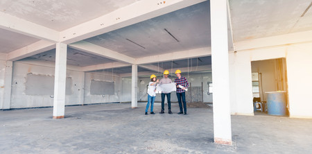 three construction engineers working together in side building planning for the renovationの写真素材