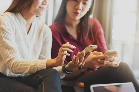Two woman using smartphone sharing data, iot, internet of things conceptualの写真素材