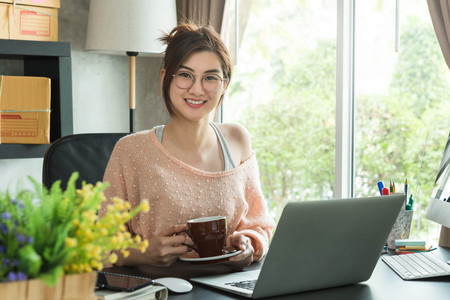 Young entrepreneur, teenager business owner work at home, alpha generation life style. morning coffee of an asian teenagerの写真素材