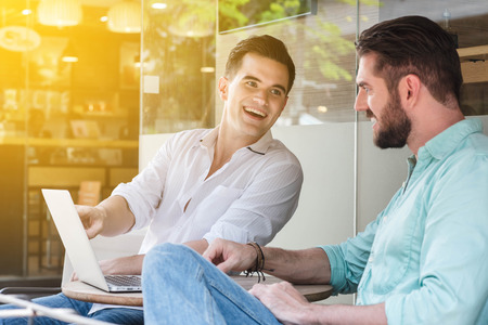Two Westerner Business men working with laptop and smartphone togetherの写真素材