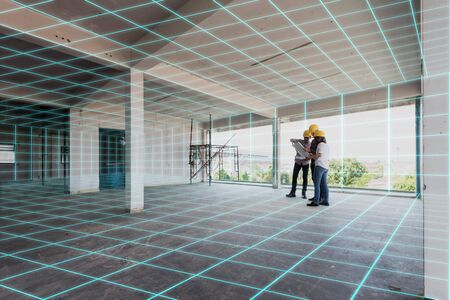 Three construction engineer discuss inside building, plan for renovation with 3d digital layoutの写真素材