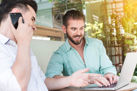 Two Westerner Business men working with laptop and smartphone togetherの写真素材