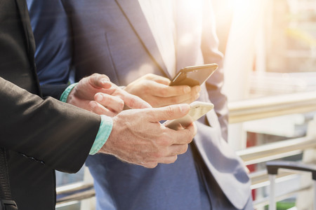 Two Westerner business man using smartphoneの写真素材