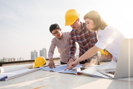 three construction engineers working outdoors in construction siteの写真素材