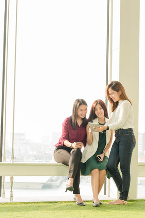 Group of friends happily hang out chatting to each other while using smartphone tablet and laptop, internet of things conceptualの写真素材