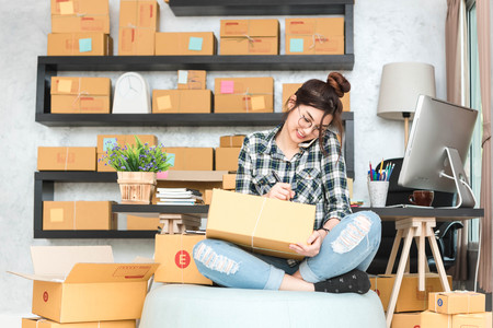 Young entrepreneur, teenager business owner work at home, alpha generation life style. phone call receive from customer and white down address for deliverの写真素材