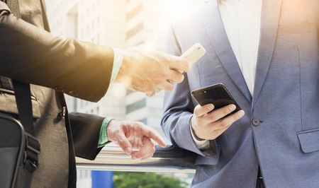 Two Westerner business man using smartphoneの写真素材