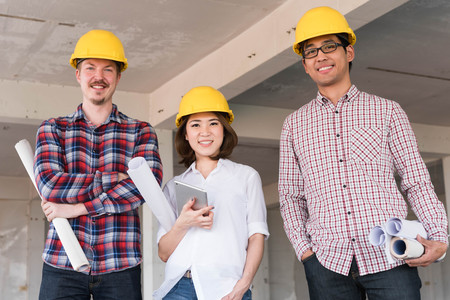 three construction engineers working together in construction site planning for the renovationの写真素材