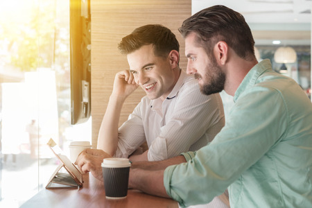 Two Westerner Business men working smartphone and tablet togetherの写真素材