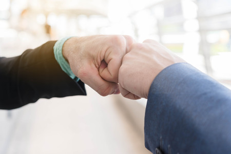 Two Westerner Business men talk and make fist bumpの写真素材