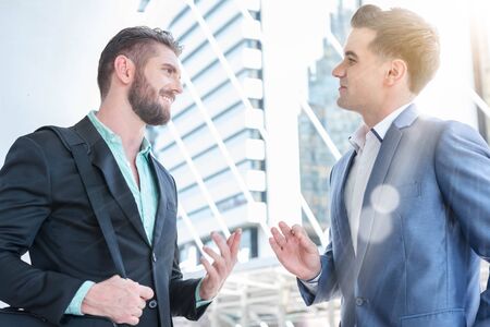 Two Westerner Business men talk and have good gesture on the public area of the walk wayの写真素材