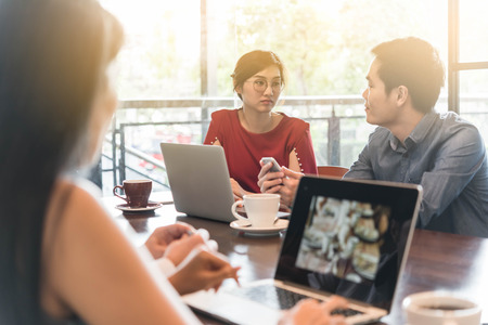 4 people meeting in coffee shop, business casual conceptualの写真素材