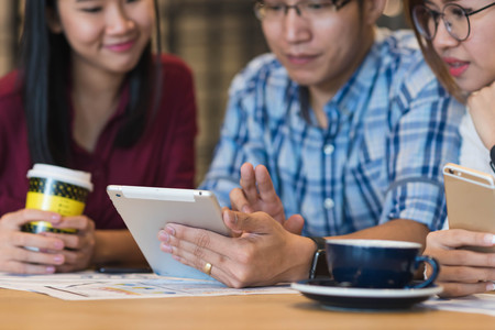Hand of man using tablet with friends, internet of things conceptualの写真素材