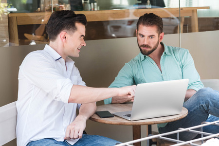 Two Westerner Business men working with laptop and smartphone togetherの写真素材