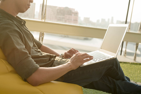 Young man use smartphone and laptop in afternoon, technology lifestyle of new generation of nomad workersの写真素材