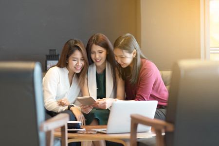 Group of friends meeting in a coffee shop chatting to each other while using smartphone tablet and laptop, internet of things conceptualの写真素材