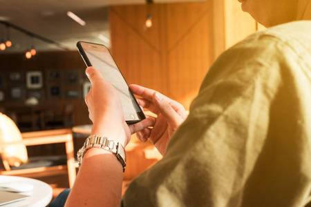 Young man use smartphone and laptop in afternoon, technology lifestyle of new generation of nomad workersの写真素材