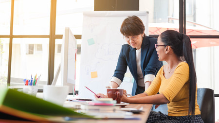 Two senior officer preparing paper work in office of creative work place, modern style of work, entrepreneur group brainstorming multi generation of creative work place, modern style of workの写真素材