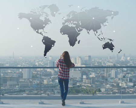 Businessman use smartphone on rooftop of building with technology effect, globalization conceptualの写真素材