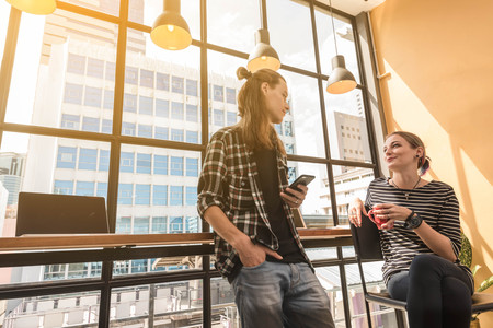 Two freelance working in coffee shop, Nomad worker conceptual, couple having fun work together in...