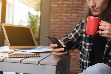 Male freelancer use smartphone and laptop in cafe, nomad worker conceptualの写真素材
