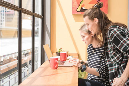 Two freelance working in coffee shop, Nomad worker conceptual, couple having fun work together in cafeの写真素材