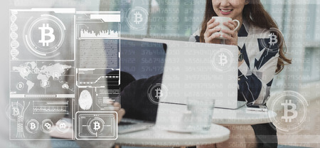 Two asian earning money from bitcoin use smartphone and laptopの写真素材