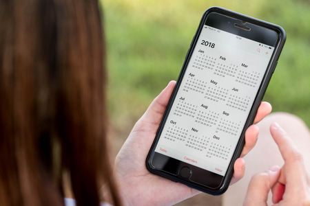 BANGKOK, THAILAND - NOVEMBER 26th, 2017: Hand of woman hold iphone 8 plus show calendar of 2018 on screenのeditorial素材