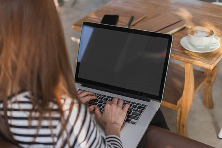 Young woman use balnk screen laptop in coffee shopの写真素材